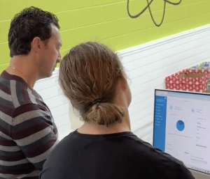 Michael Benso teaching a gym staff member how to use BUZOPS Gym Management Software to read reports directly from business dashboard