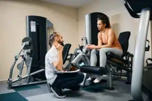 Gym trainer talking to member